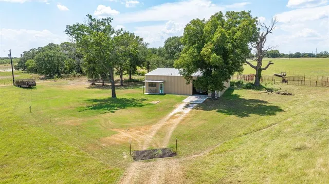 a view of a swimming pool with a yard and large trees