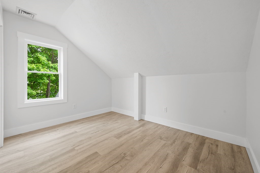 91 Schofield Avenue Dudley, MA 01571 - Photo 14 of 27 an empty room with wooden floor and windows