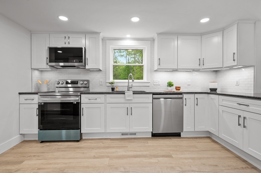 91 Schofield Avenue Dudley, MA 01571 - Photo 7 of 27 a kitchen with stainless steel appliances granite countertop a stove a sink and a microwave