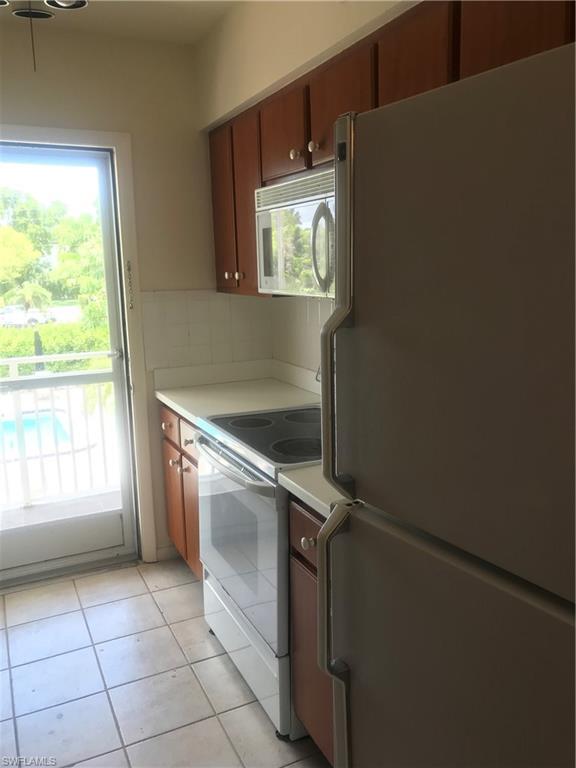 216 Banyan Boulevard, Unit 216 Naples, FL 34102 - Photo 31 of 33 a view of a kitchen with washer and dryer