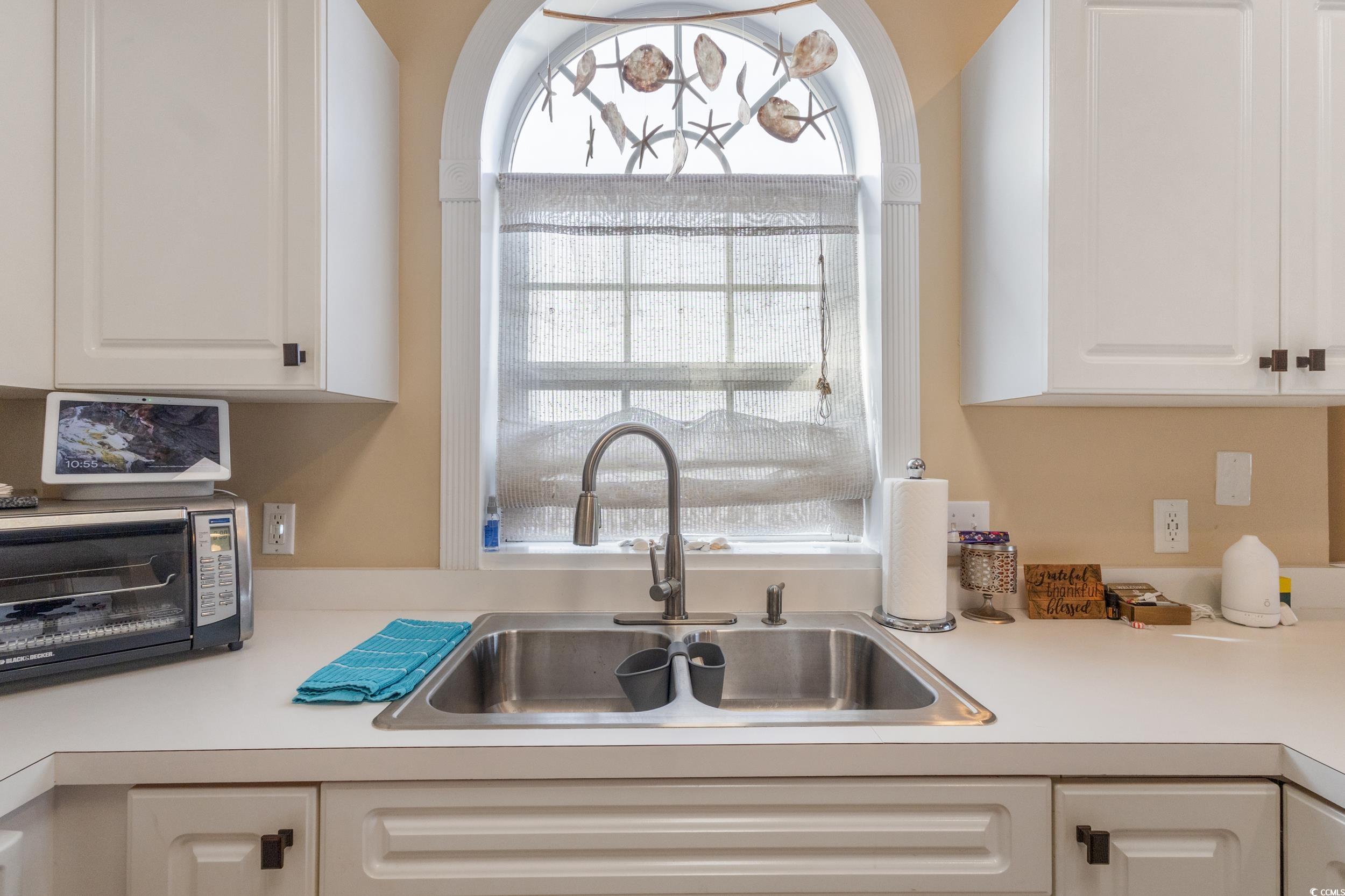 4781 Wild Iris Drive, Unit 301 Myrtle Beach, SC 29577 - Photo 15 of 33 Kitchen with light countertops, healthy amount of natural light, and white cabinetry