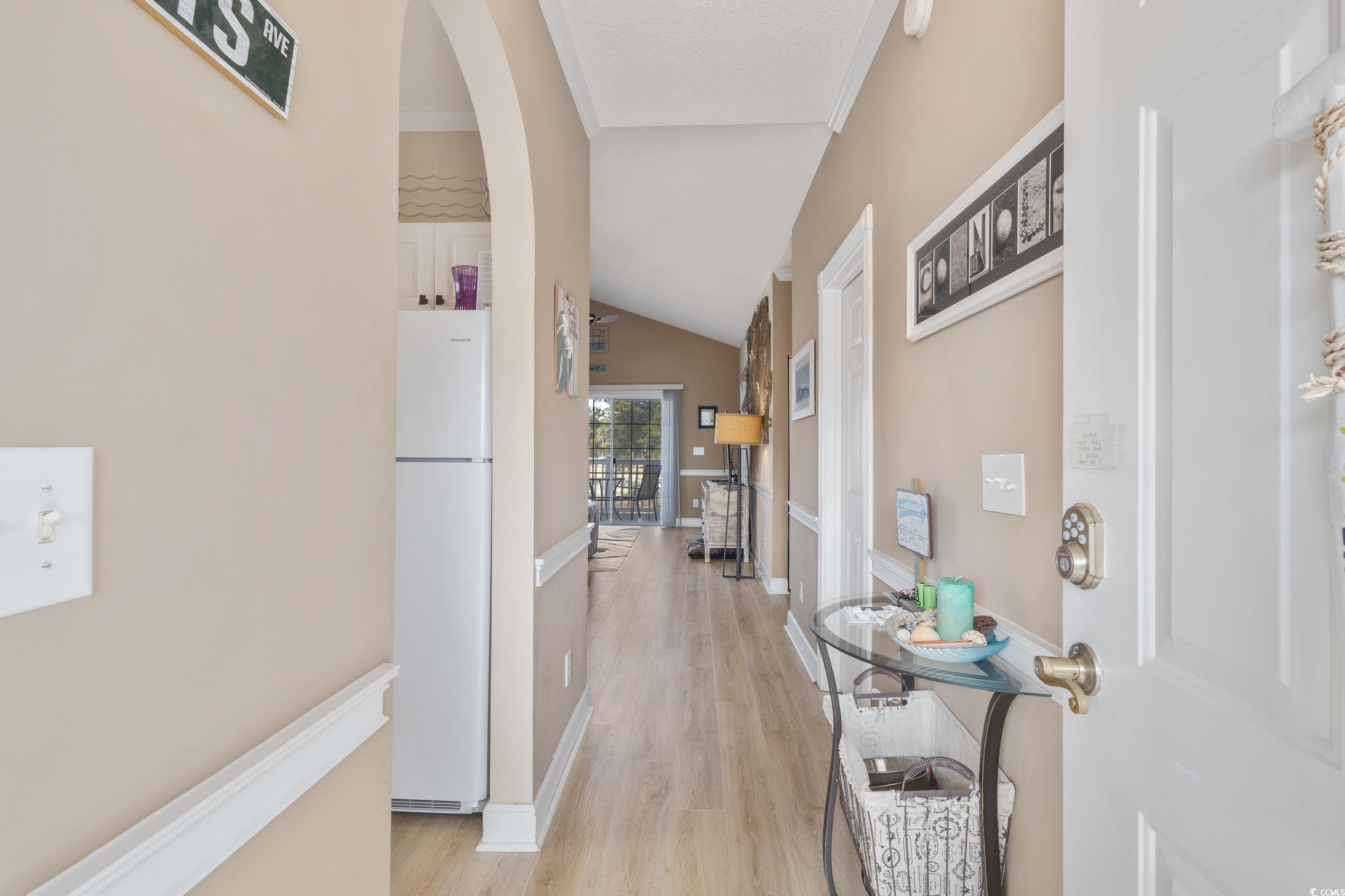 4781 Wild Iris Drive, Unit 301 Myrtle Beach, SC 29577 - Photo 27 of 33 Corridor with arched walkways, light wood-style flooring, lofted ceiling, and ornamental molding