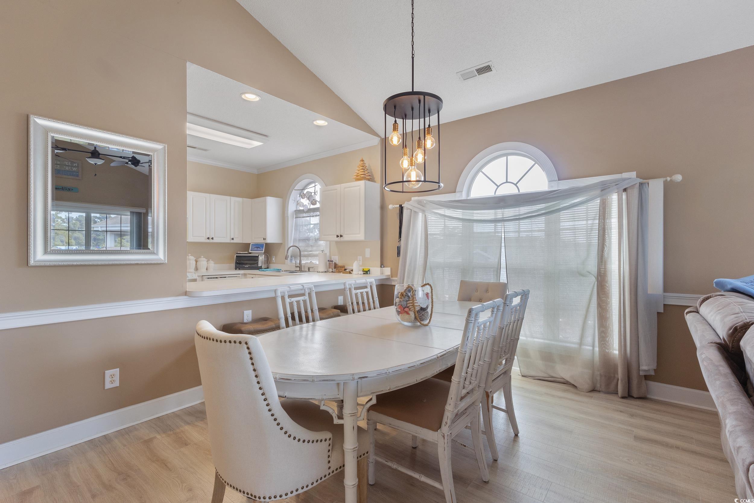 4781 Wild Iris Drive, Unit 301 Myrtle Beach, SC 29577 - Photo 9 of 33 Dining room featuring lofted ceiling, light wood-type flooring, a chandelier, ornamental molding, and recessed lighting