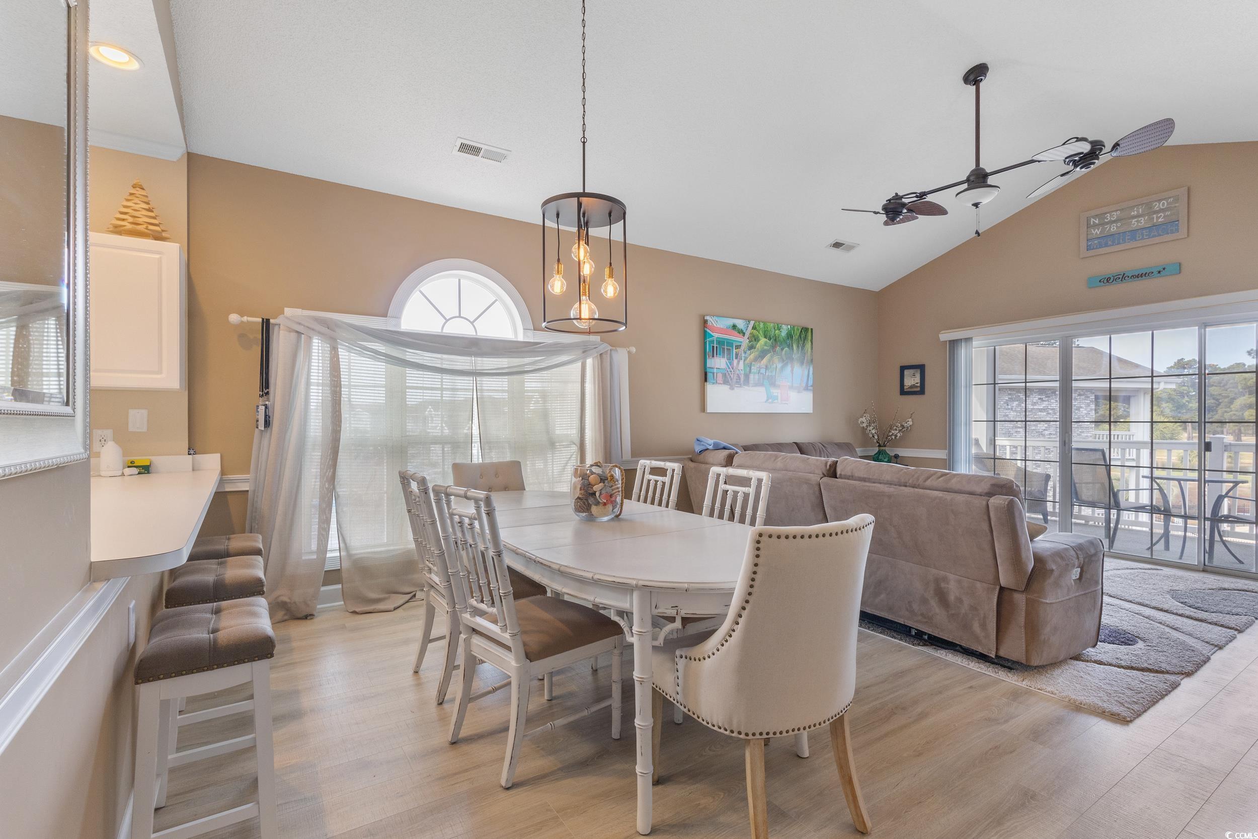 4781 Wild Iris Drive, Unit 301 Myrtle Beach, SC 29577 - Photo 10 of 33 Dining room with lofted ceiling, a ceiling fan, and light wood-style flooring