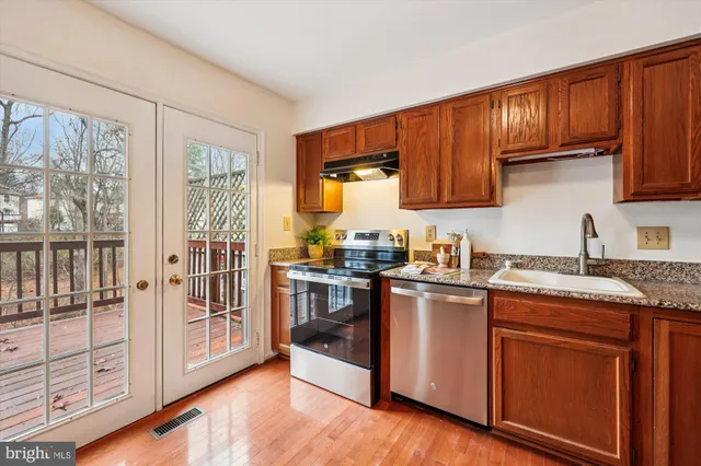 a kitchen with stainless steel appliances granite countertop a stove top oven sink and cabinets