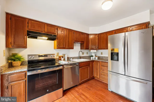 a kitchen with a refrigerator sink and wooden cabinets