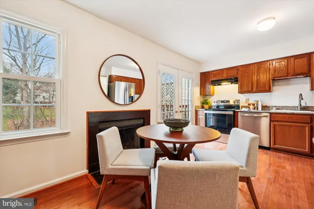 a view of a dining room with furniture a potted plant and wooden floor
