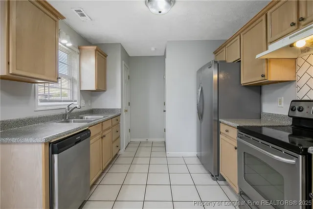 a kitchen with stainless steel appliances granite countertop a sink stove and cabinets