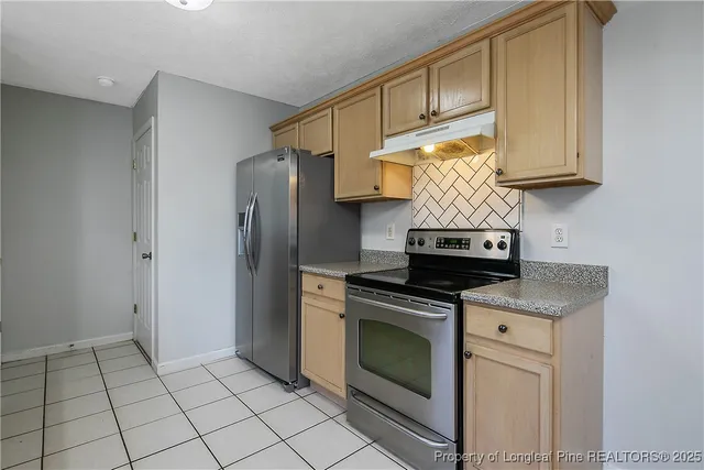 a kitchen with stainless steel appliances granite countertop a stove a refrigerator and a microwave