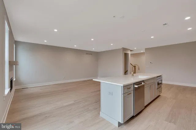 a large kitchen with kitchen island a sink stainless steel appliances and white cabinets
