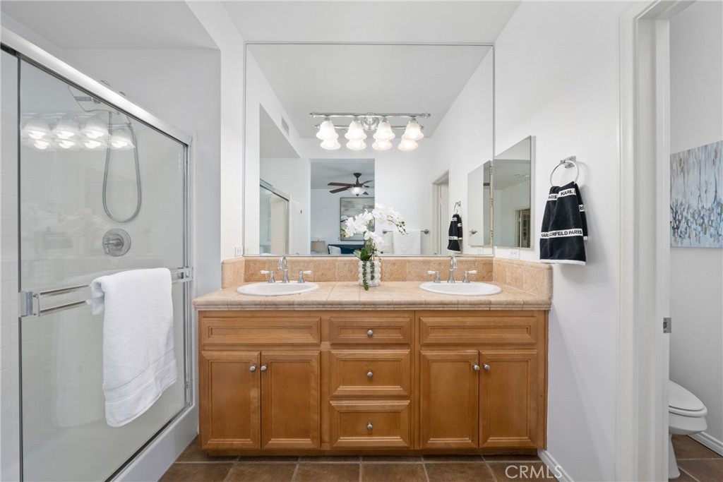 322 Dewdrop Irvine, CA 92603 - Photo 12 of 26 a bathroom with a granite countertop sink a mirror and a shower
