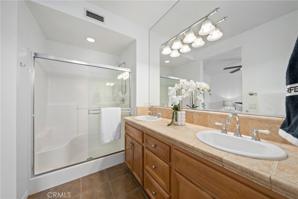 322 Dewdrop Irvine, CA 92603 - Photo 13 of 26 a bathroom with a granite countertop sink a mirror and a shower