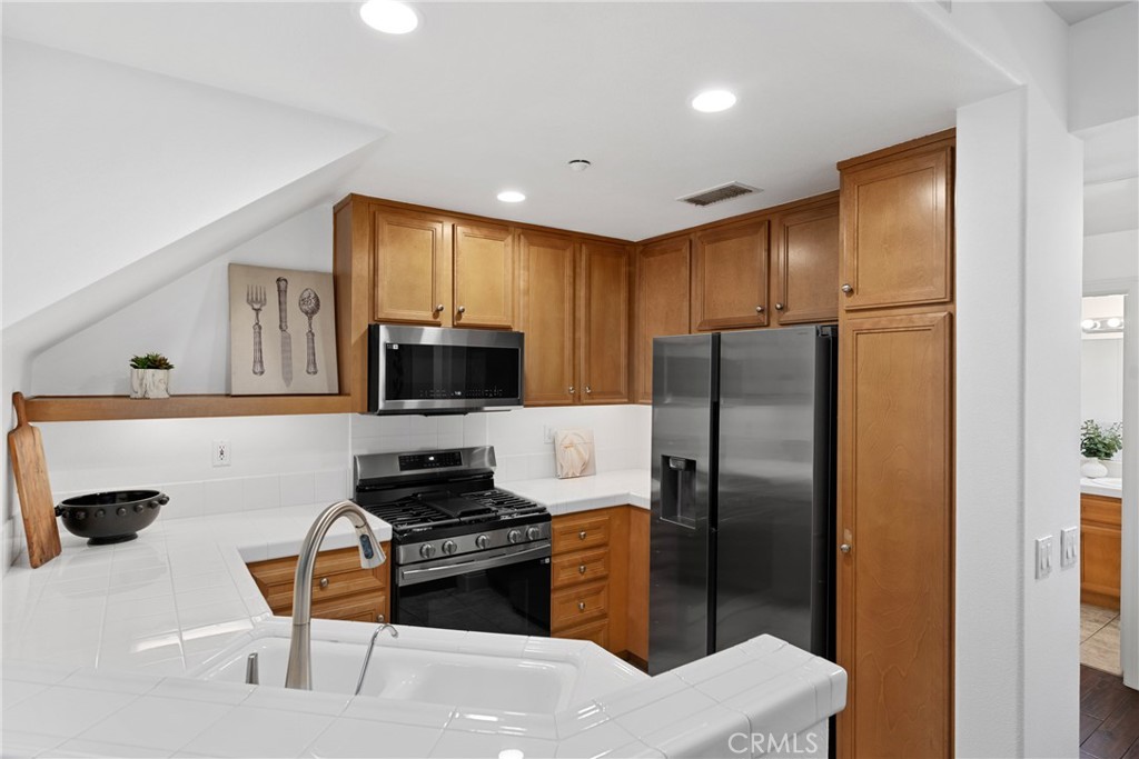 322 Dewdrop Irvine, CA 92603 - Photo 6 of 26 a kitchen with granite countertop a refrigerator stove top oven a sink and dishwasher