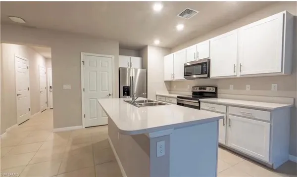 a kitchen with kitchen island a sink stainless steel appliances and cabinets