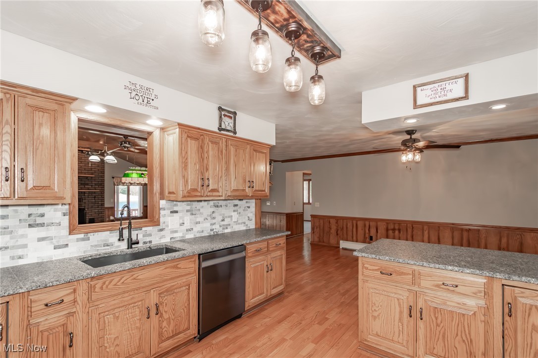 2866 South County Line Road Madison, OH 44057 - Photo 23 of 48 Kitchen with wainscoting, a sink, stainless steel dishwasher, and ceiling fan