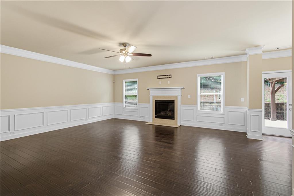 114 Madison Street Canton, GA 30115 - Photo 10 of 39 an empty room with wooden floor fireplace and windows