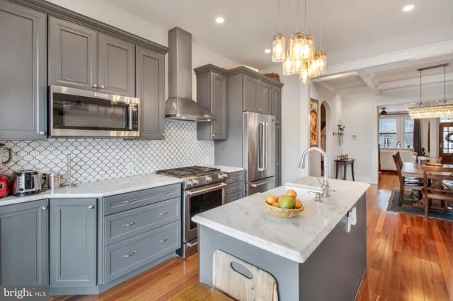 a kitchen with granite countertop a sink stove and refrigerator