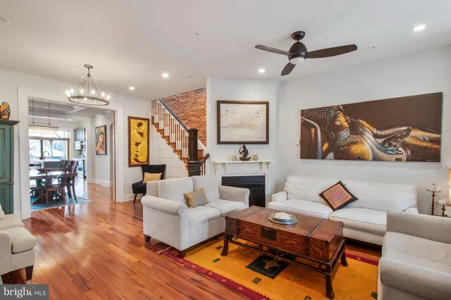 a living room with furniture kitchen view and a chandelier