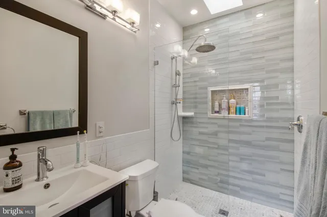 a bathroom with a sink a toilet and shower