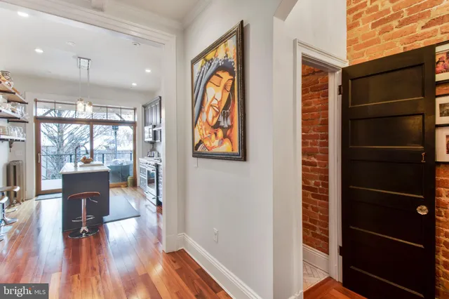 a view of a hallway with wooden floor and dining room