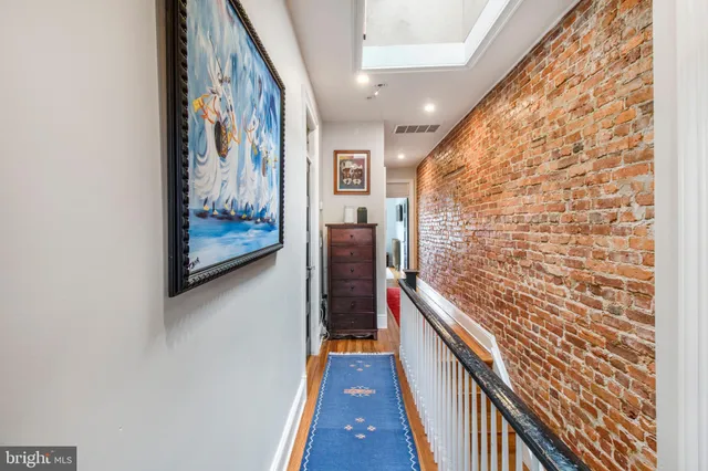 a hallway with wooden floor and brick walls