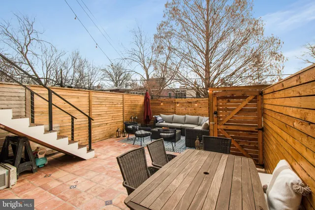 a balcony with wooden floor and outdoor seating
