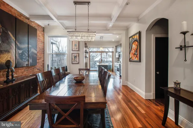 a view of a dining room with furniture a chandelier and wooden floor