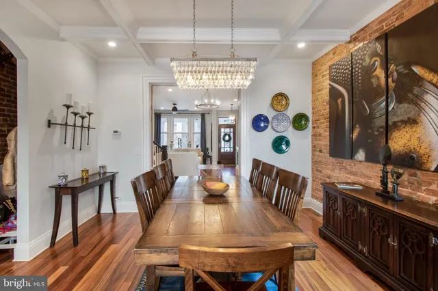 a view of a dining room with furniture a chandelier and wooden floor