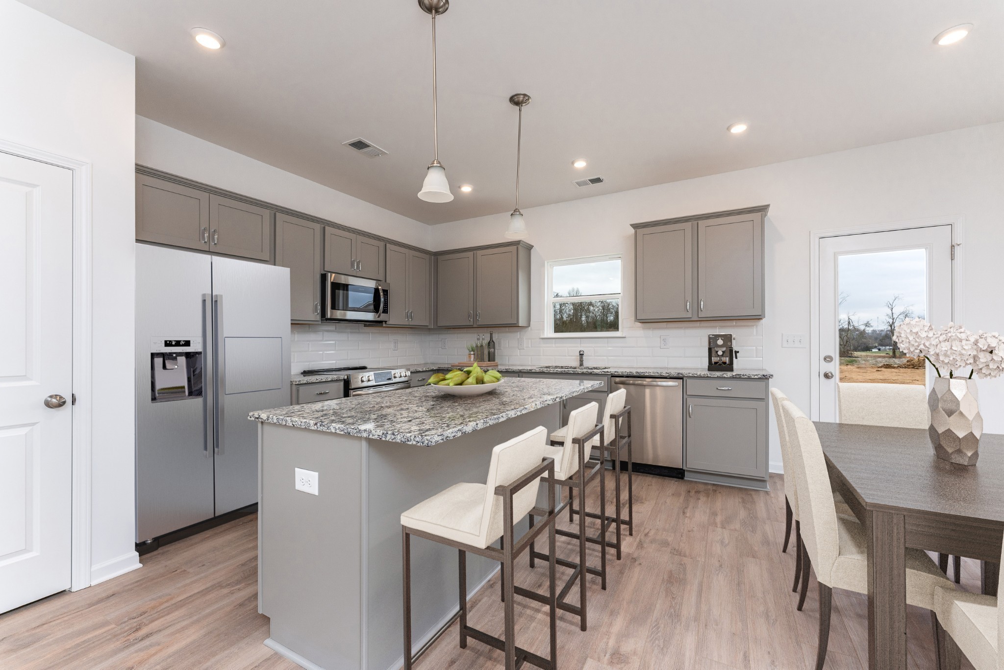356 Winston Way Gallatin, TN 37066 - Photo 9 of 28 a kitchen with stainless steel appliances granite countertop a refrigerator a sink dishwasher a stove a dining table and chairs with wooden floor