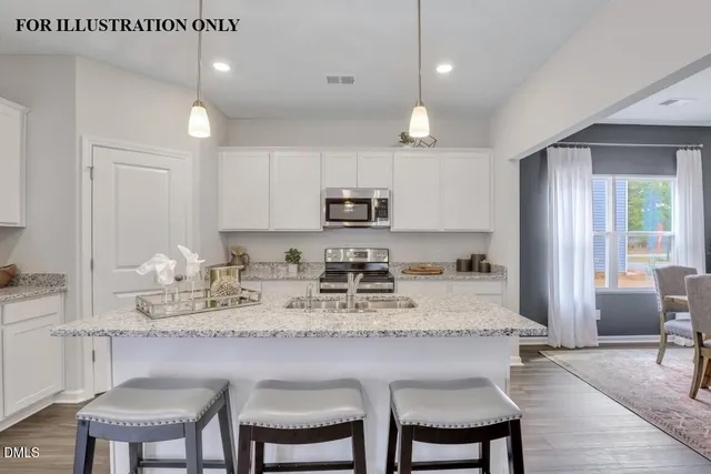 a kitchen with stainless steel appliances granite countertop a stove a sink and a microwave