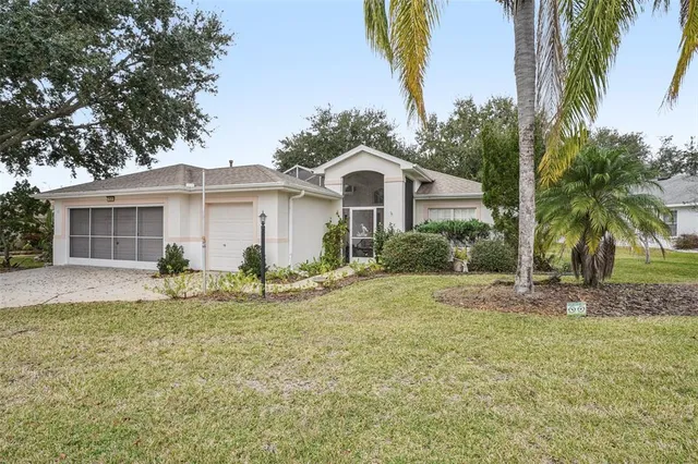 a view of a house with a yard and palm trees