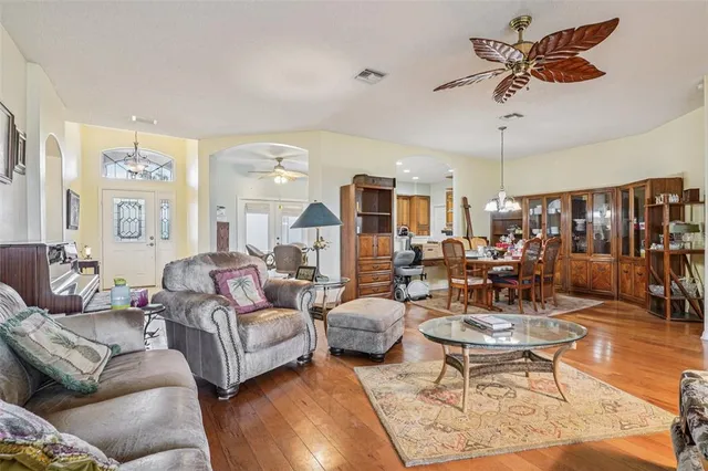 a living room with furniture kitchen view and a large window