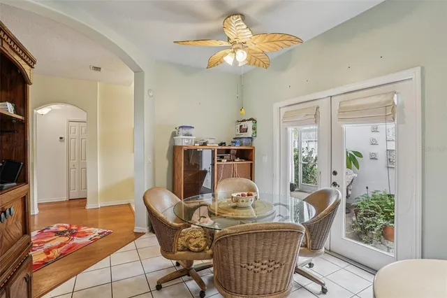 a dining room with furniture a rug a potted plant and a chandelier