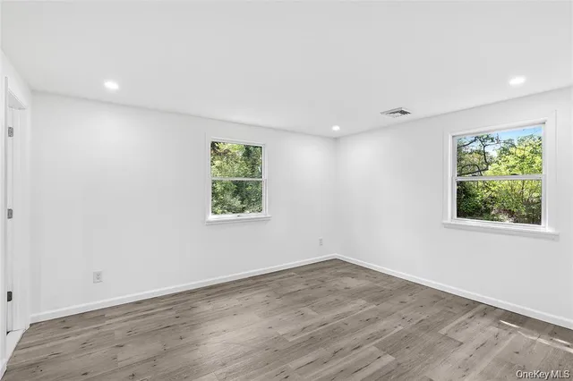 an empty room with wooden floor and window