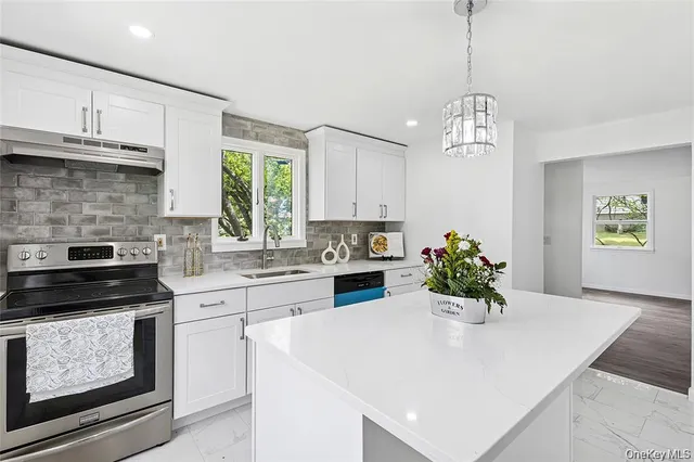 a kitchen with stainless steel appliances kitchen island a table and chairs in it