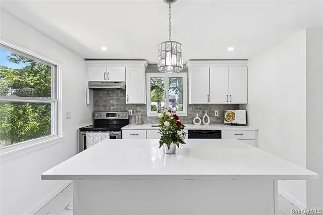 a kitchen with a stove a window and cabinets