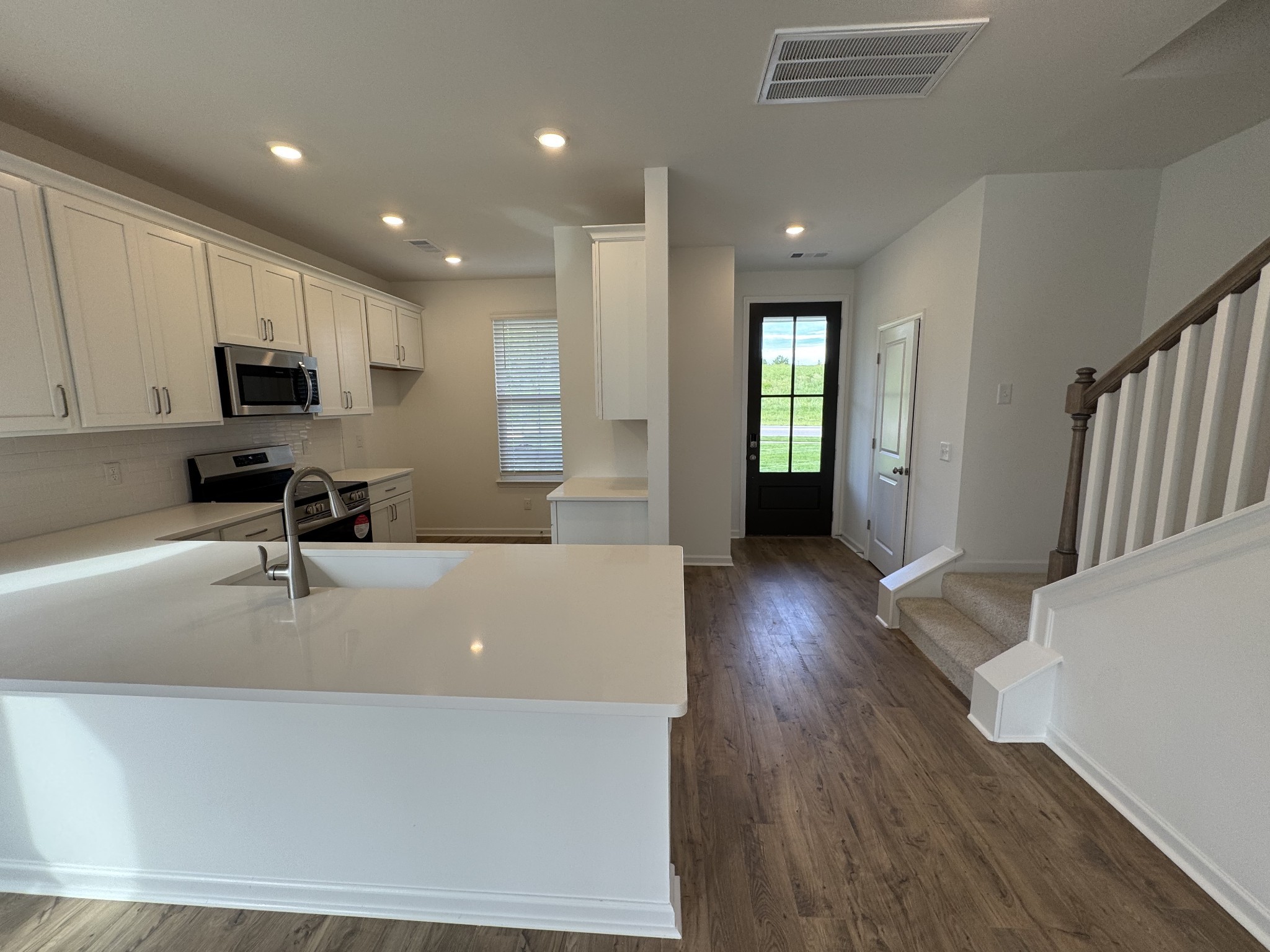 410 Blair Road Smyrna, TN 37167 - Photo 4 of 27 a large white kitchen with wooden floors and a fireplace