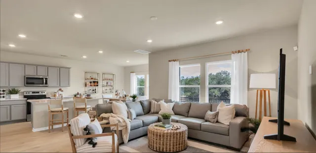 a living room with furniture flat screen tv and a large window