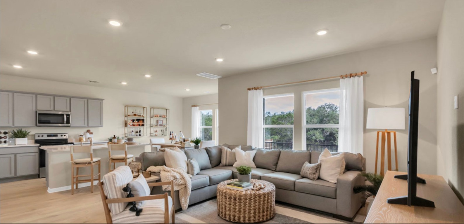 a living room with furniture flat screen tv and a large window