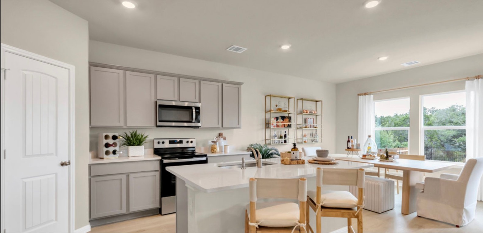 257 Frogmore Loop Kyle, TX 78640 - Photo 4 of 20 a kitchen with a sink a stove a refrigerator and white cabinets with wooden floor