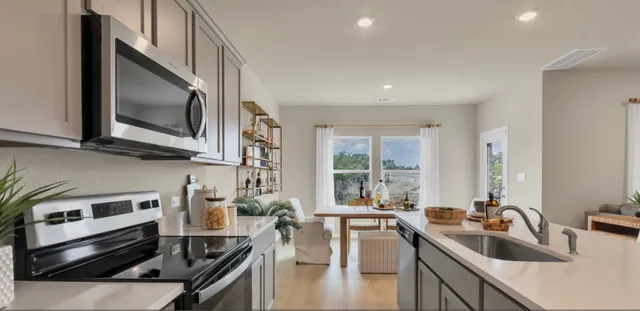 a kitchen with stainless steel appliances granite countertop a sink stove and microwave