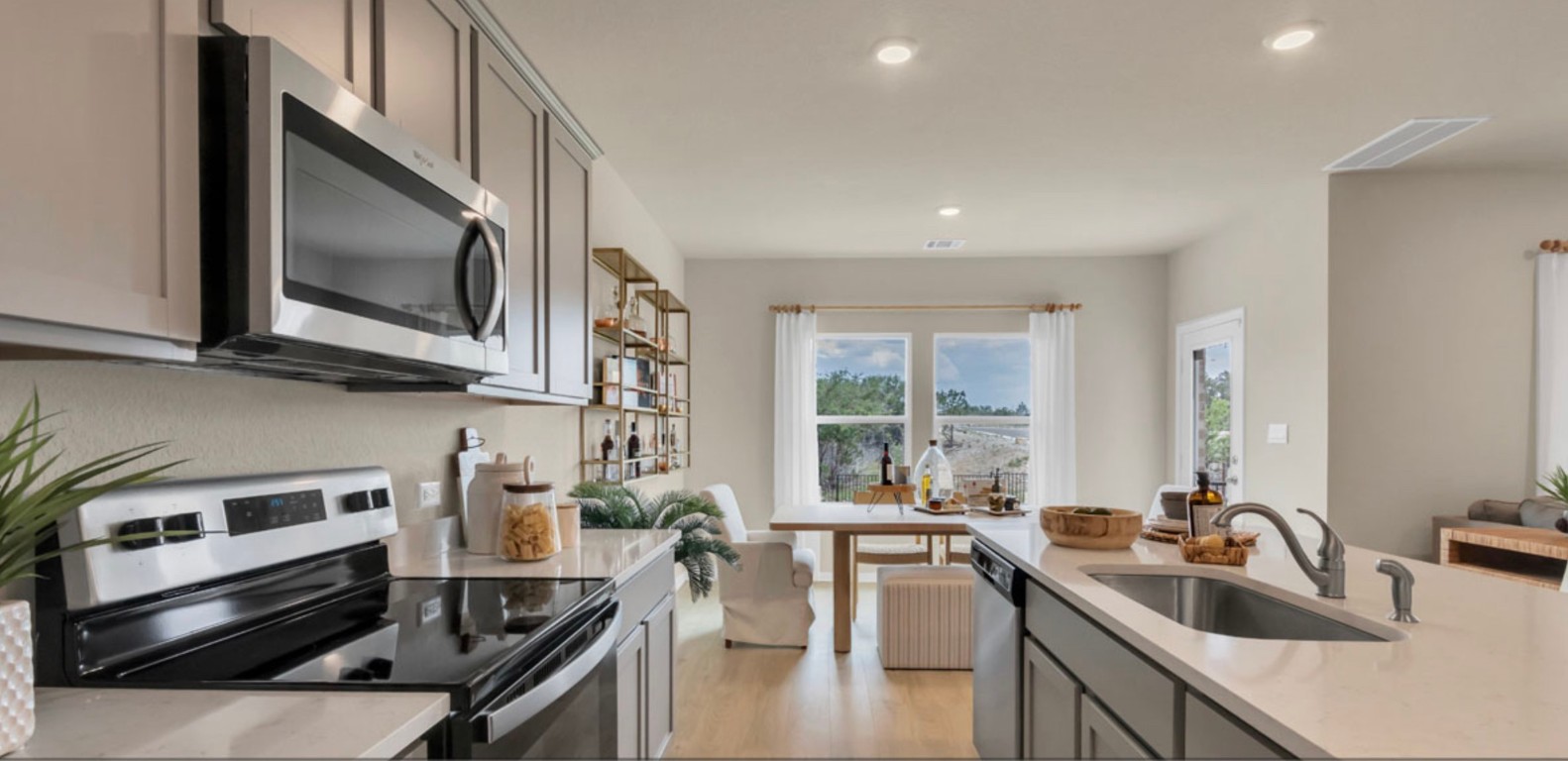257 Frogmore Loop Kyle, TX 78640 - Photo 5 of 20 a kitchen with stainless steel appliances granite countertop a sink stove and microwave