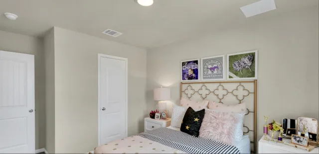 a bedroom with a bed and a lamp