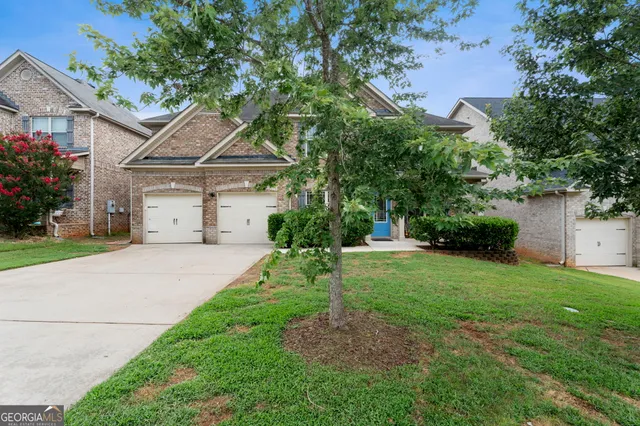 a white house that has a tree in front of it