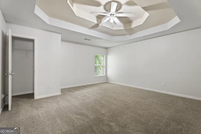 a view of an empty room with closet and a window