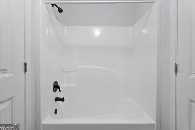 a white toilet sitting next to a white wall