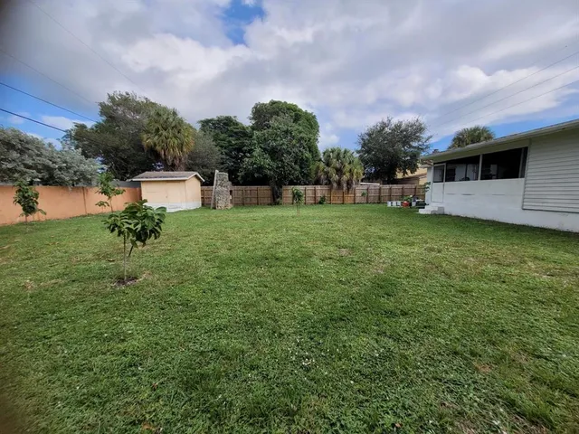 a backyard of a house with table and chairs