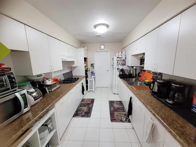 a kitchen with granite countertop a sink stove and cabinets