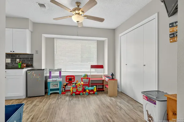 a children room with furniture and a ceiling fan