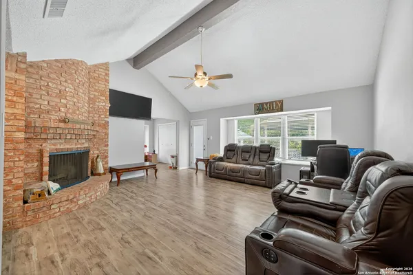 a living room with furniture a fireplace and a flat screen tv